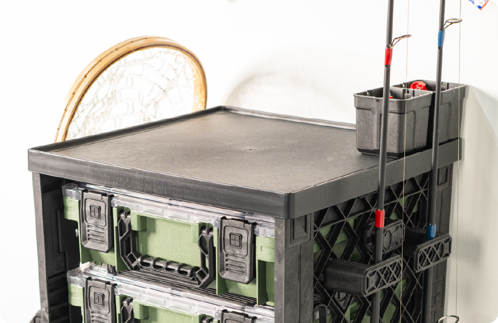 Black UbeCube fishing setup with stacked BaseBoxes, a work surface, and side-mounted fishing rods.