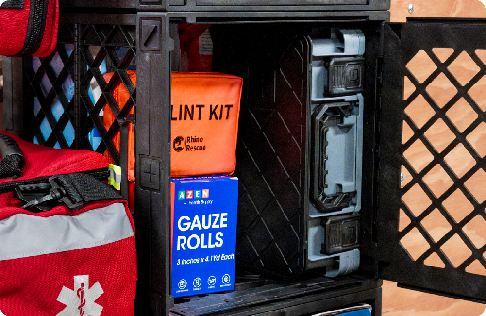Black UbeCube crate storing first aid supplies, a splint kit, gauze rolls, and a gray medical case behind an open crate door.