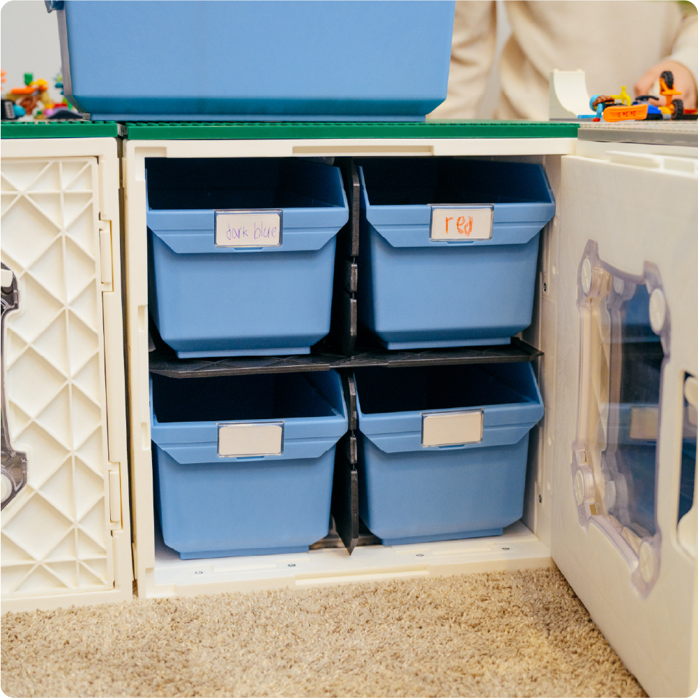 White UbeCube CratePlay setup with four blue Grabinet Bins organized inside a crate for sorting LEGO-compatible bricks by color.
