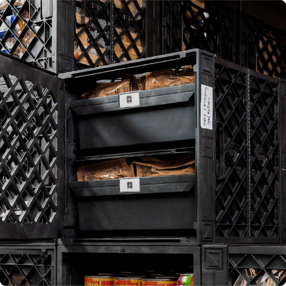 Black UbeCube prepper storage setup with stacked Grabinet Bins organizing emergency food rations inside a crate.