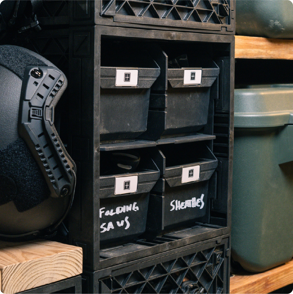 Black UbeCube hunting storage setup with labeled Grabinet Bins organizing folding saws, sheaths, and outdoor gear.
