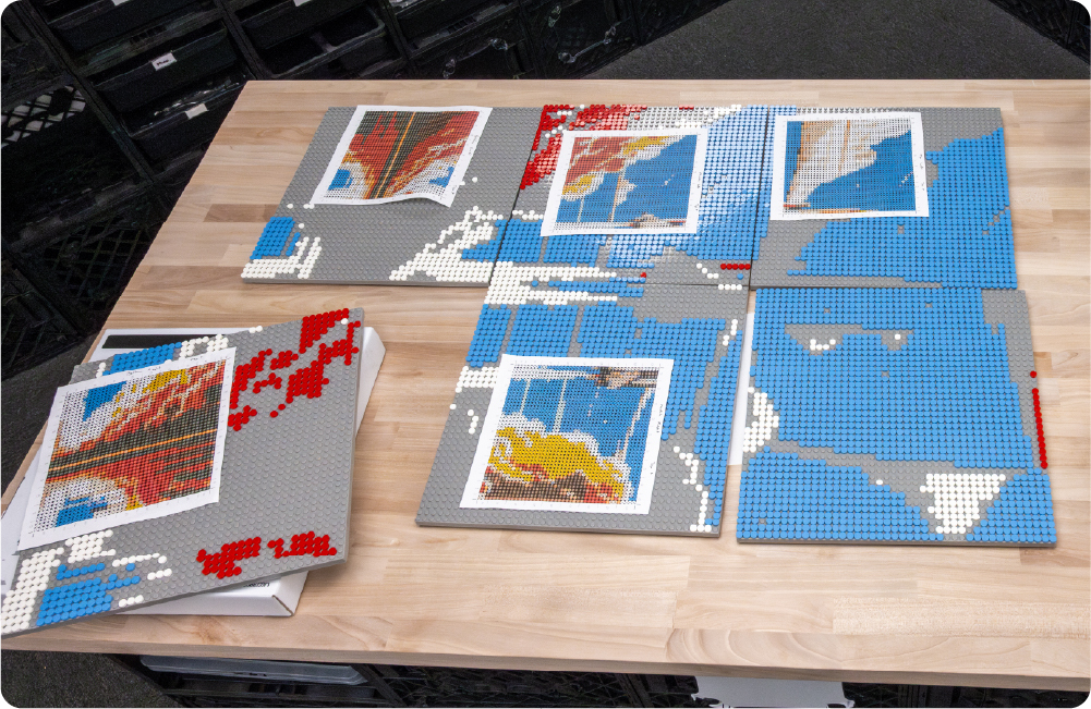 Multiple Pixel Panels arranged on a table with colored studs forming a large pixel art image from printed templates.