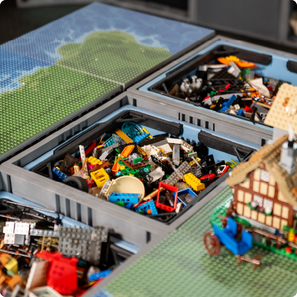 Gray UbeCube CratePlay setup with Drop-In Trays filled with LEGO-compatible bricks and build plates arranged as play surfaces.