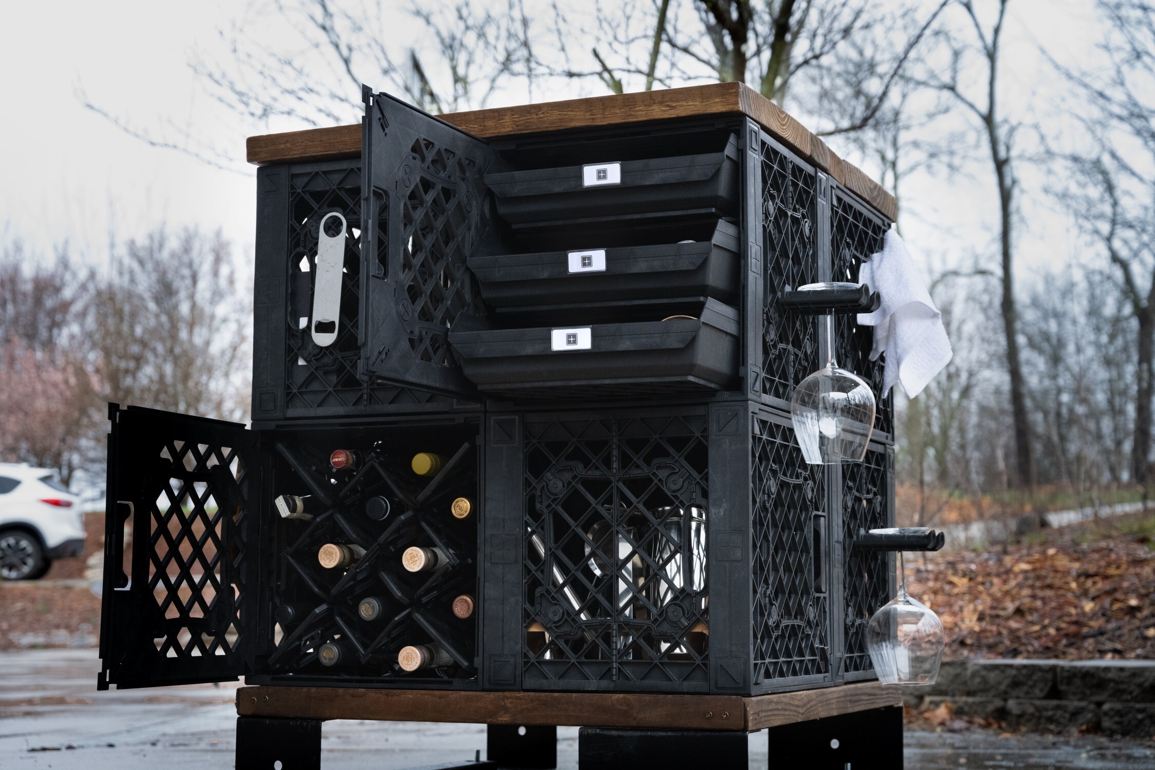 Outdoor wine cart style setup with open doors, bottle storage, and drawers.