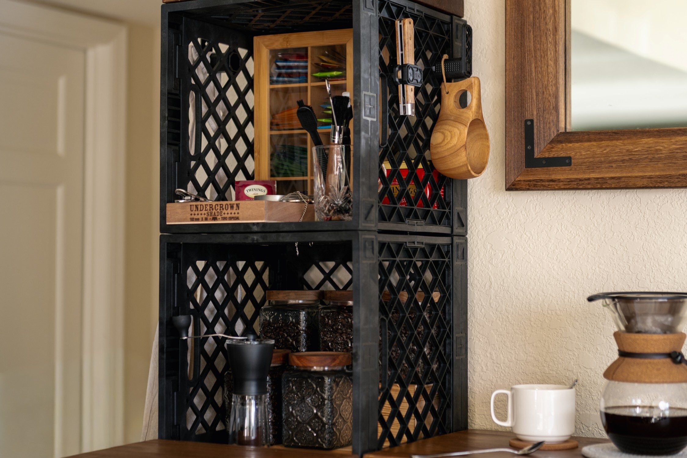 Vertical crate tea station with tea bags, jars, mugs, and tools.