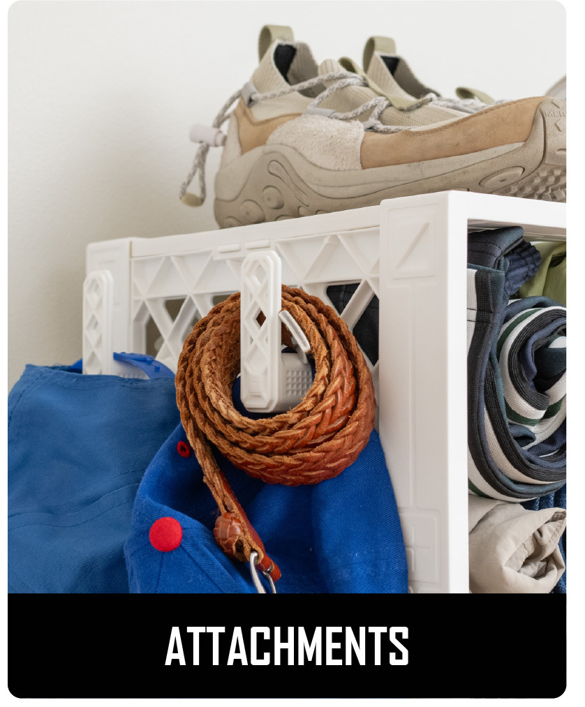 White CratePlay™ crate setup with outer hooks holding a rope, clothing, and rolled gear beside stored shoes.