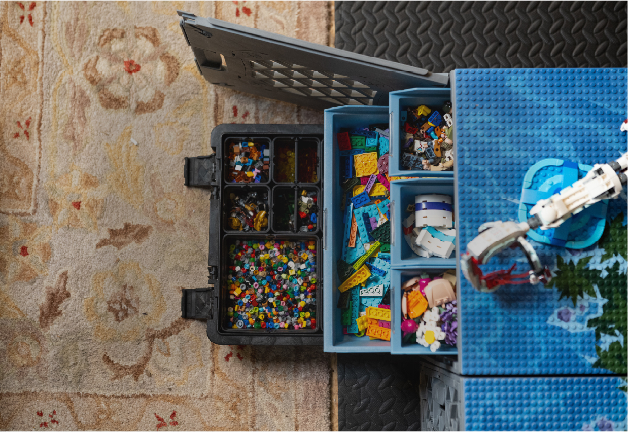 CratePlay™ toy storage setup with blue bins, black storage trays, building bricks, and a play surface.