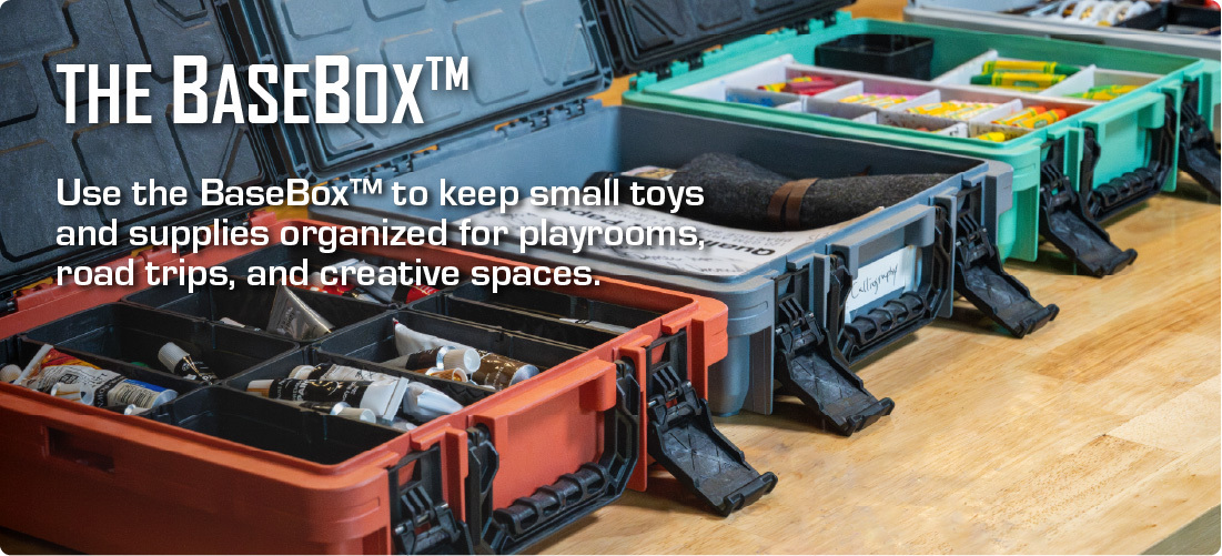 BaseBox™ organizers with open lids, divided compartments, toys, art supplies, and small parts arranged on a tabletop.