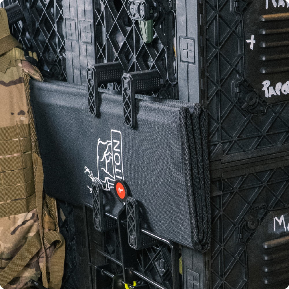 Black UbeCube storage setup with CrateHooks holding a folded gear pouch and accessory tools on the side grid.