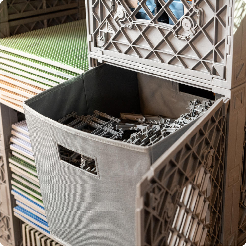 Gray full-size Fabric Bin filled with LEGO-compatible track pieces inside a gray UbeCube CratePlay storage setup.