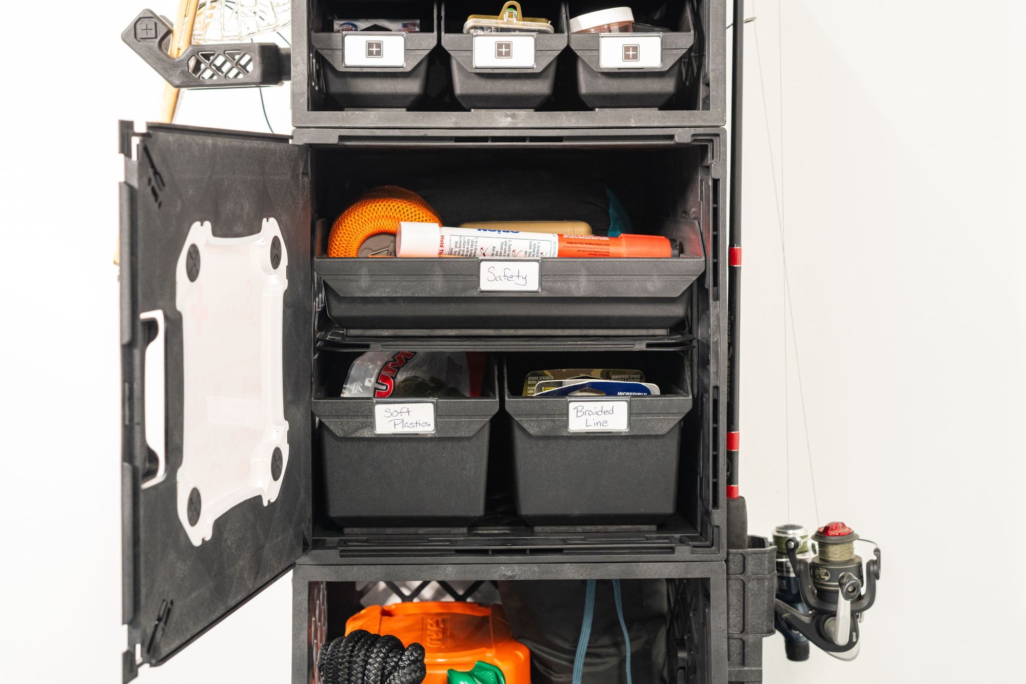 CrateWhite TackleStack fishing gear organization system set up in a garage with rods, tackle, trays, and outdoor gear
