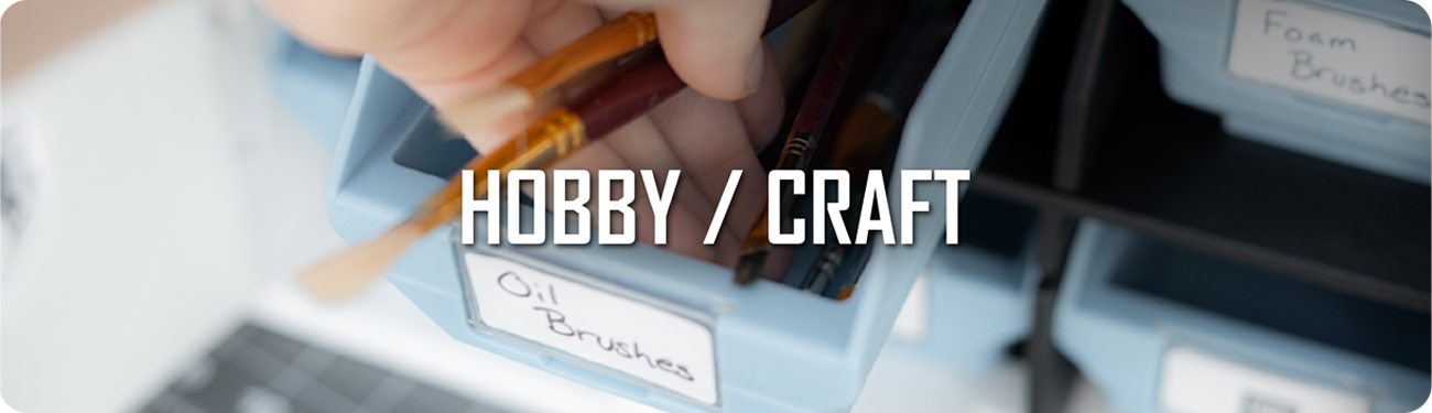 UbeCube storage system with labeled bins for art supplies, showing a hand pulling out a drawer of oil brushes, labeled ‘HOBBY / CRAFT’.