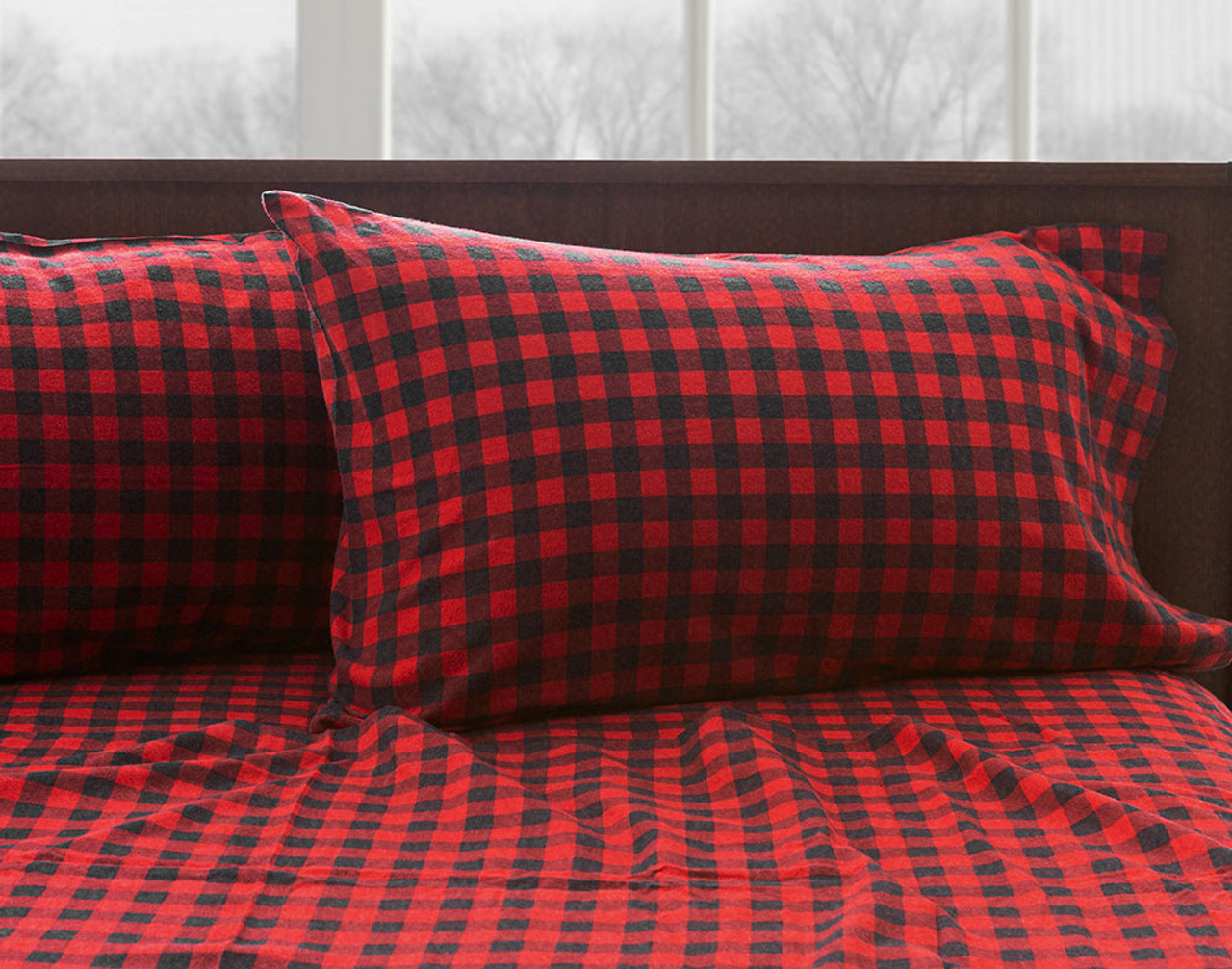 Our red Flannel Cotton Sheet Set in Buffalo dressed over a bed.