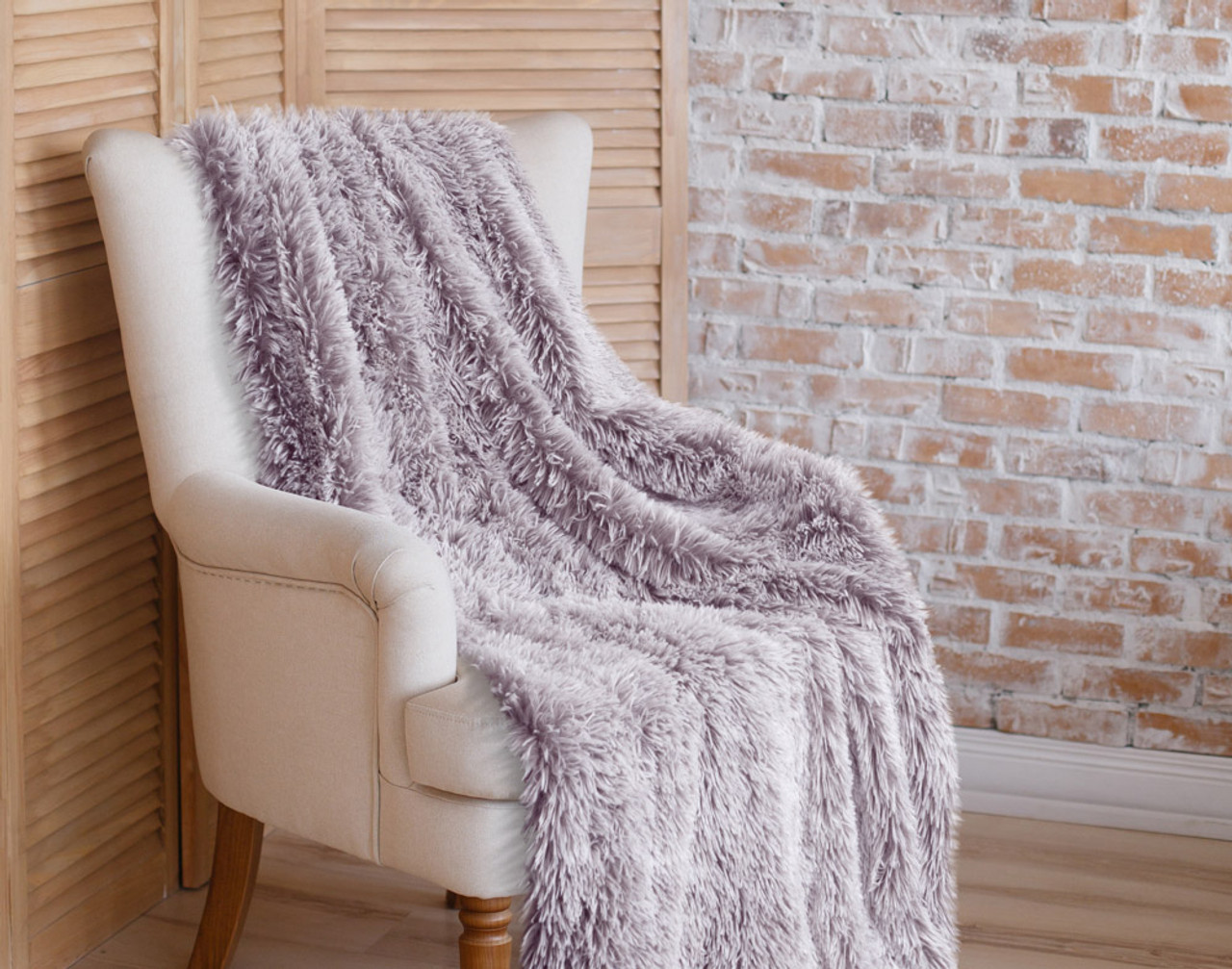 Our Frosted Shaggy Throw in Plum Purple draped over a chair.