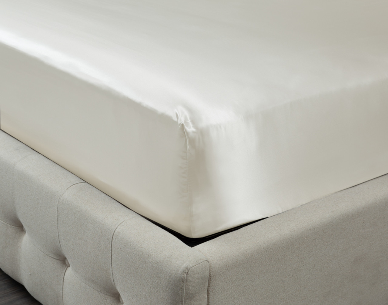 Corner of our Mulberry Silk Fitted Sheet in White Snow over the corner of a mattress.