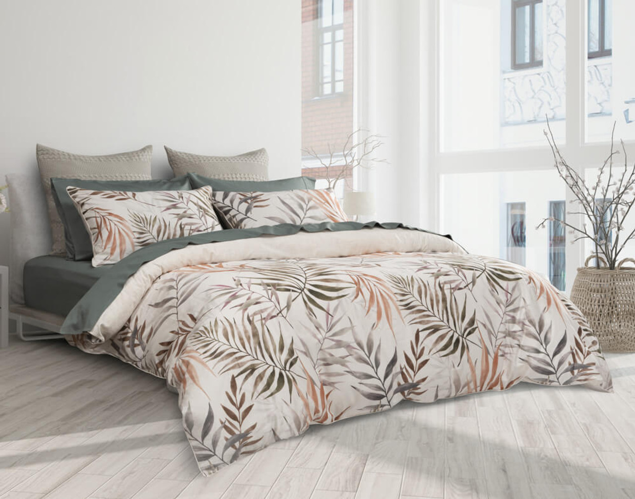 Our San Luca Duvet Cover with tropical frond design dressed over a bed with dark green sheets in a white bedroom.