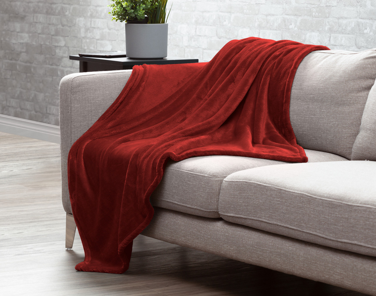 Our Merlot Red Velvet Plush Throw draped over a couch.