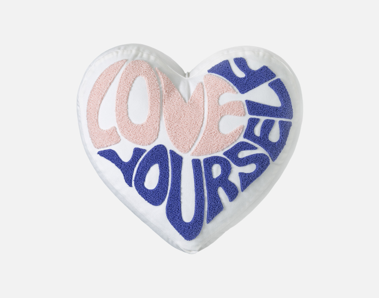 Vue de face de notre coussin Love Yourself BeaYOUtiful en forme de cœur sur un fond blanc uni.