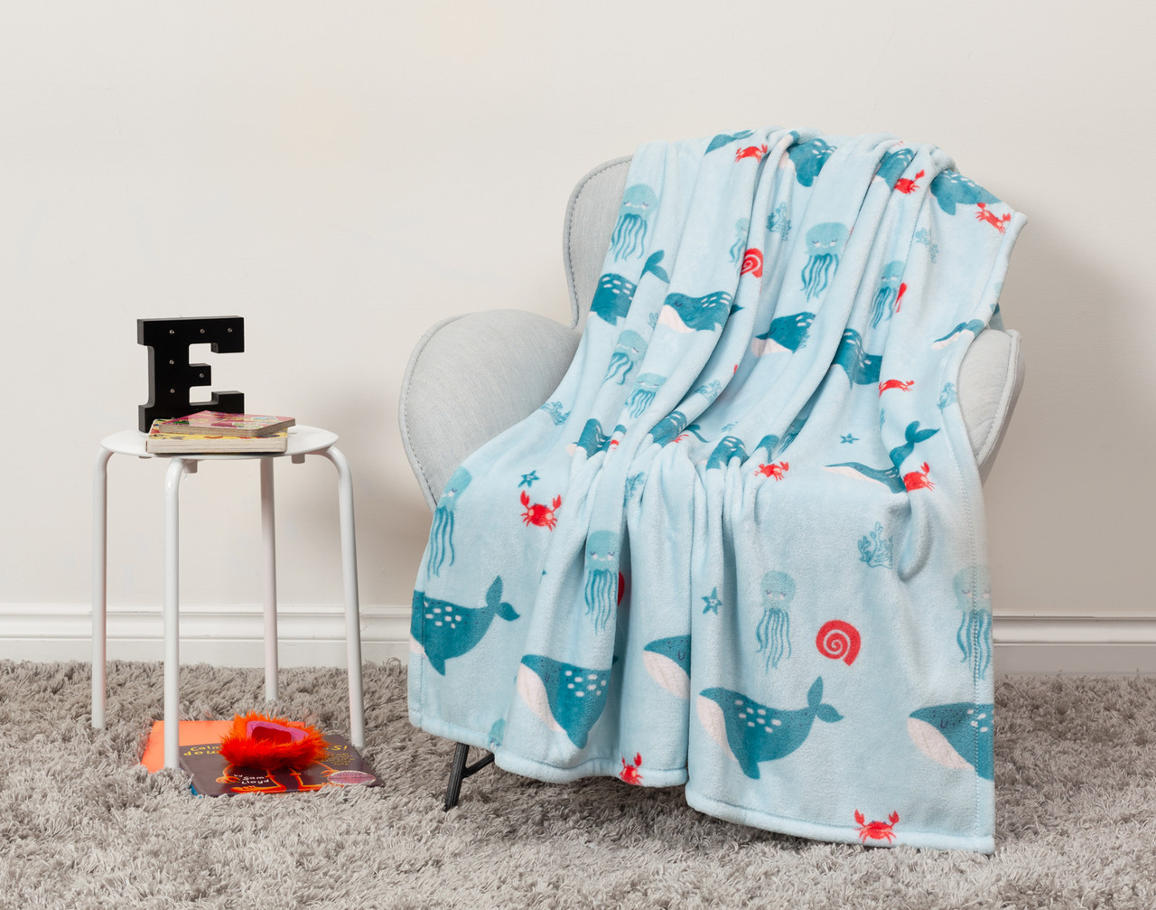 Front view of our Whaley Kids' Fleece Velveteen Throw draped over a chair in a kids' room.