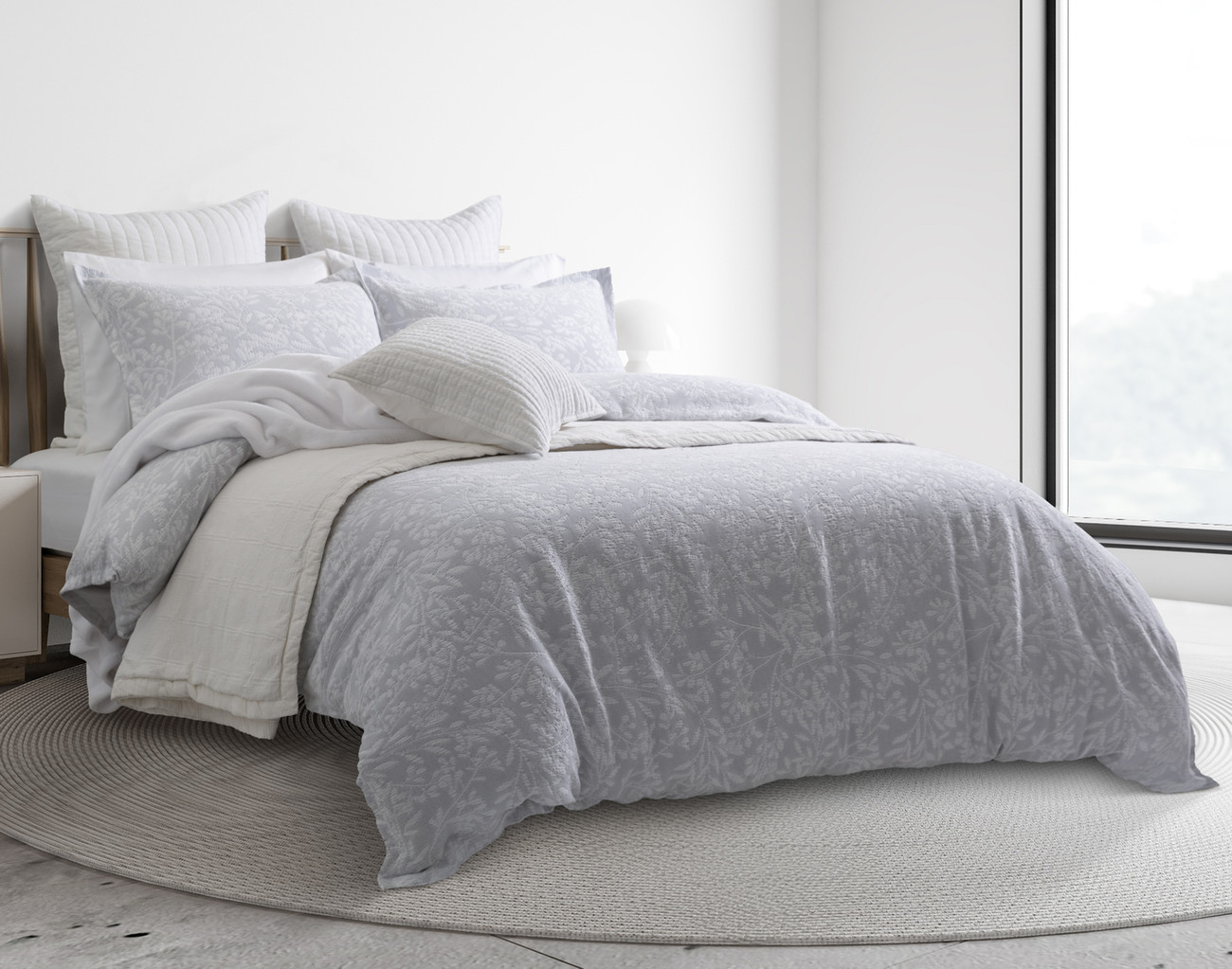 Angled view of our Tavira Duvet Cover dressed over a queen bed in a sunny hotel-style bedroom.