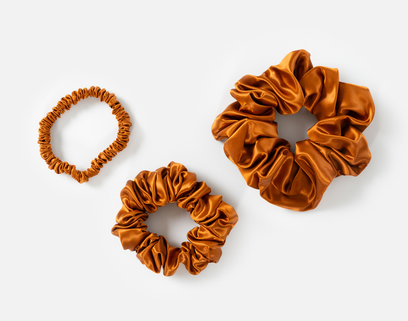Vue de dessus des petits, moyens et grands chouchous de notre ensemble chouchous Orange Soie de mûrier .