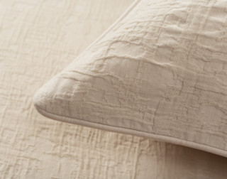 Close-up on the corner of our Stonehaven Beige Pillow Sham to show its light piped edge.