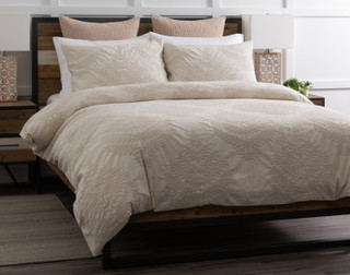 Angled view of our Marcona Duvet Cover Set dressing a queen bed in a simple bedroom.