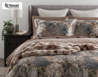 Closer front, off-centre view of our Captiva Duvet Cover dressing a queen bed with accessories.