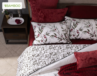 Top-down view of the head of a bed dressed in our Laurentian Duvet Cover with matching accessories and Black Cherry Sheets.