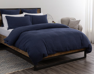 Angled side view of our Kye Duvet Cover Set dressing a queen bed with white sheets.