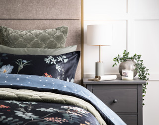 Front, off-centre view of our Sarita Duvet Cover dressed with our Bonsai Sheets and matching green quilt set.