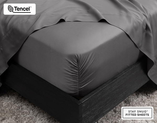 Close-up of the corner on our BeechBliss TENCEL™ Modal Fitted Sheet in Pewter Grey snugly fit over a mattress with a flat sheet draped on top.