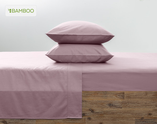Two of our Bamboo Cotton Pillowcases in Orchid Purple stacked on top of each other on a coordinating pink bed.