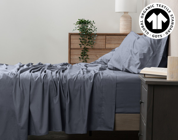 Side view of our Organic Cotton Sheet Set in Waterway to show its flat sheet draped over the side.