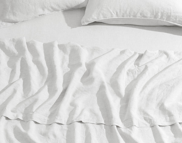 Vue du dessus de notre Signature European Linen Flat drap en blanc légèrement ébouriffé sur un lit queen avec un lit assorti drap.