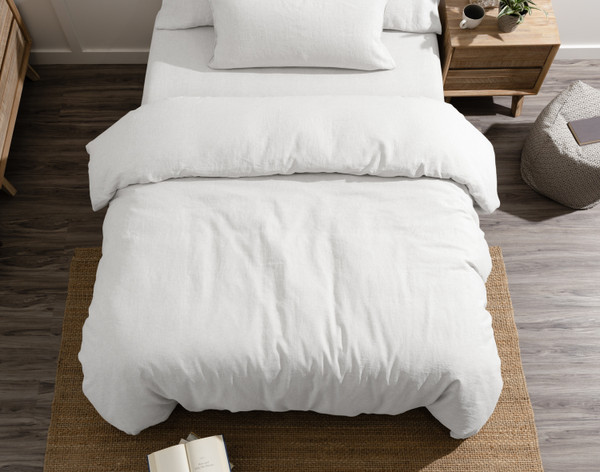 Vue de dessus de notre housse de couette Signature European Linen en blanc, habillée sur un lit queen avec un oreiller queen centré au niveau de la tête.