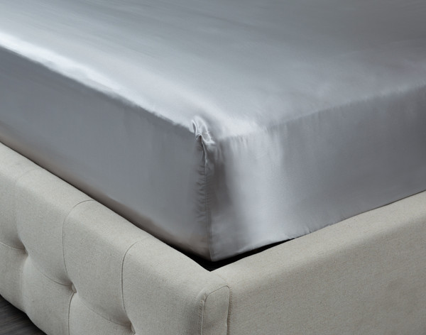 Corner of our Mulberry Silk Fitted Sheet in Silver over the corner of a mattress.