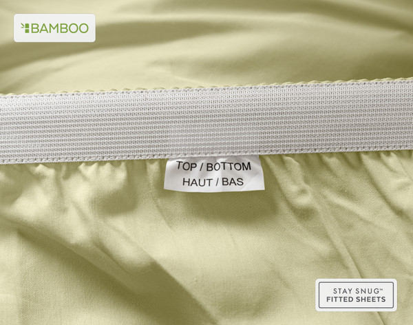 Edge of our Bamboo Cotton Fitted Sheet in Elm Green to show a tag stating "Top" and "Bottom."