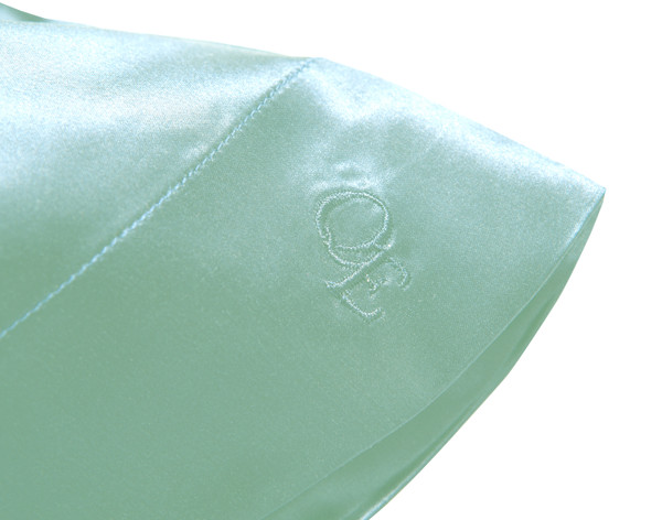 Opening corner on our Mulberry Silk Pillowcase in Fountain Blue with embroidered QE Home logo.