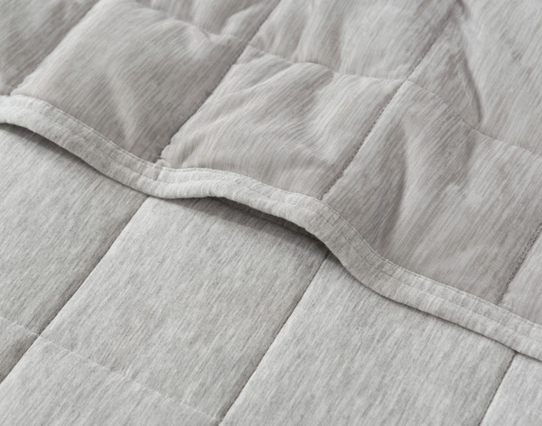 Edge of our All-Seasons Weighted Blanket to show its box stitching and light grey colour.