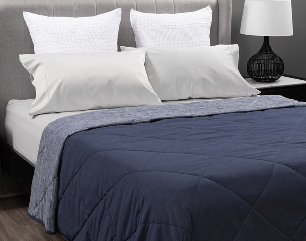 Couverture Cool Touch en bleu marine dans une chambre à coucher.
