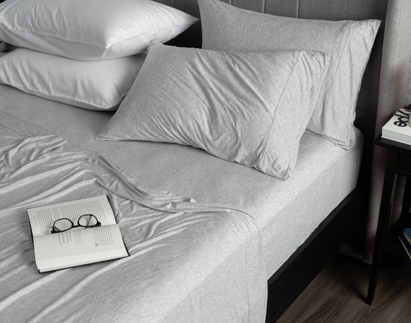 Angled view of our Bamboo Jersey Sheet Set with a book and glasses over it.