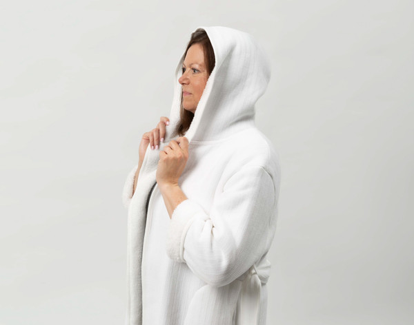 Closer view of woman wearing our Chenille Sherpa Bathrobe in White against a solid white background with hood raised over her head.