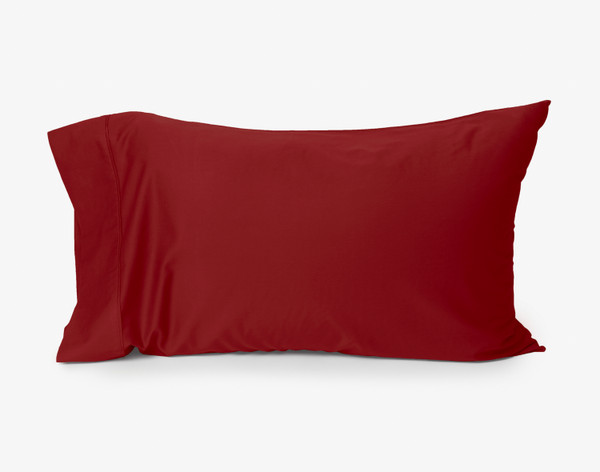 Our Eucalyptus Luxe TENCEL™ Lyocell Pillowcase in Ruby Red sitting against a solid white background.