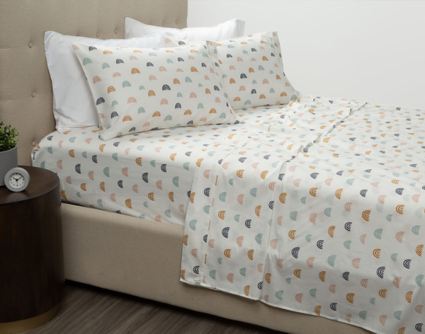 Rainbow Dreamer Organic Cotton Sheet Set draped over a bed.
