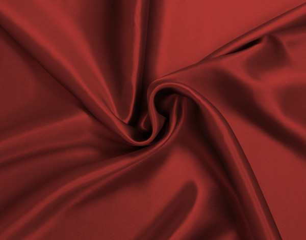 Furled up fabric on our Mulberry Silk Pillowcase in Ruby Red to show its luxuriously smooth surface.