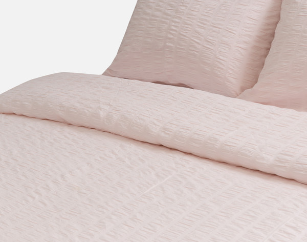 Gros plan sur le bord supérieur roulé de notre housse de couette Rosa Pink.