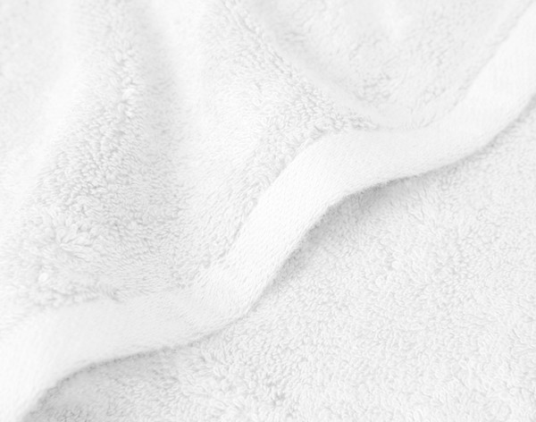 Close-up on the smooth edge border on our Modal Cotton Bath Mats in White sitting against a solid white background.