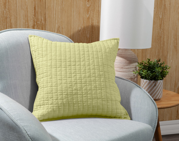 Our Linen Cotton Square Cushion Cover in _______ leaning in a grey armchair.