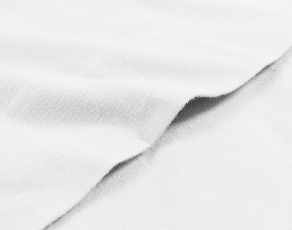 Close-up on the edge of the flat sheet for our Organic Flannel Cotton Sheet Set in White to show its triple brushed finish.